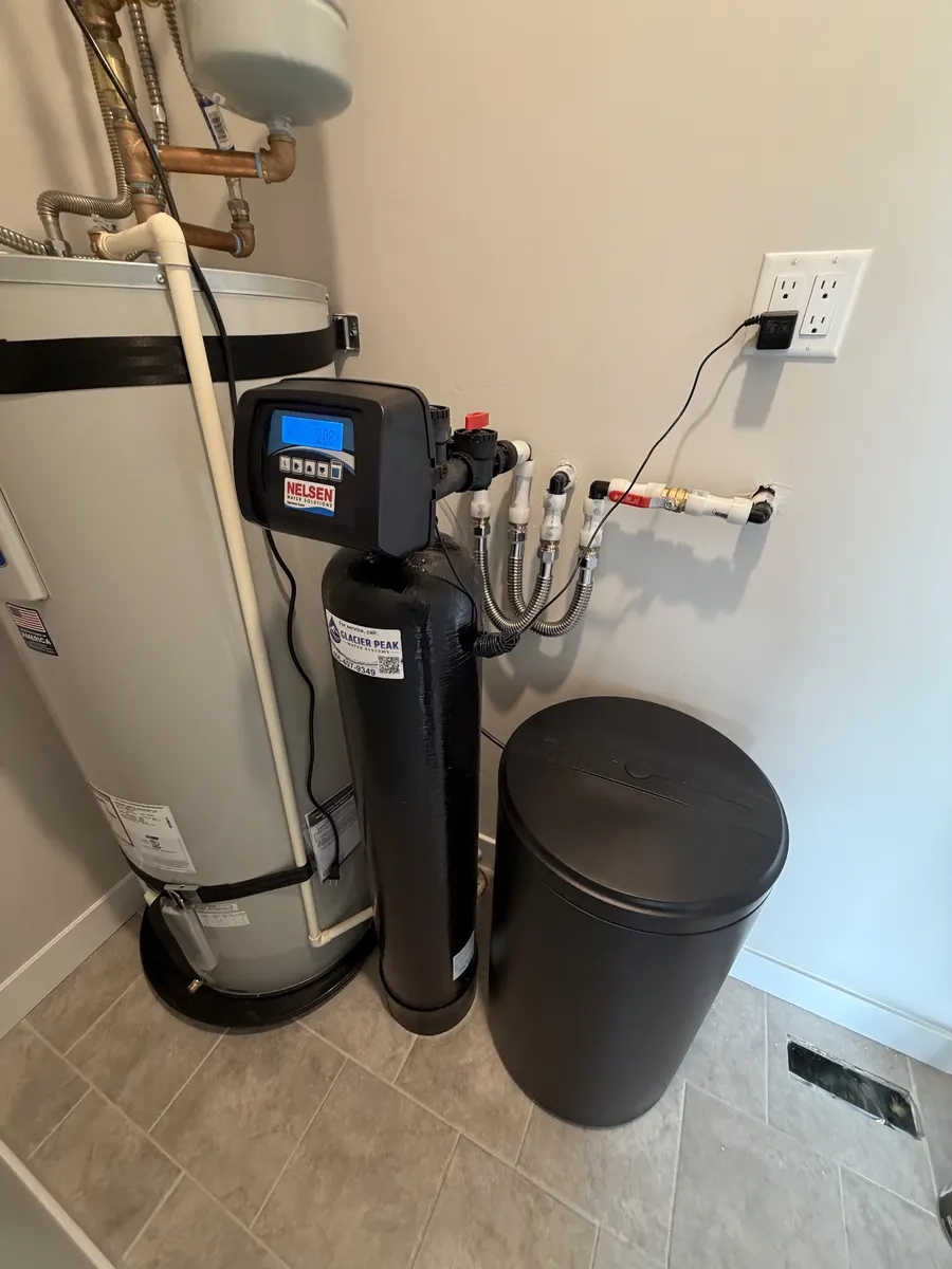 Black water conditioning tank and brine tank installed beside a water heater